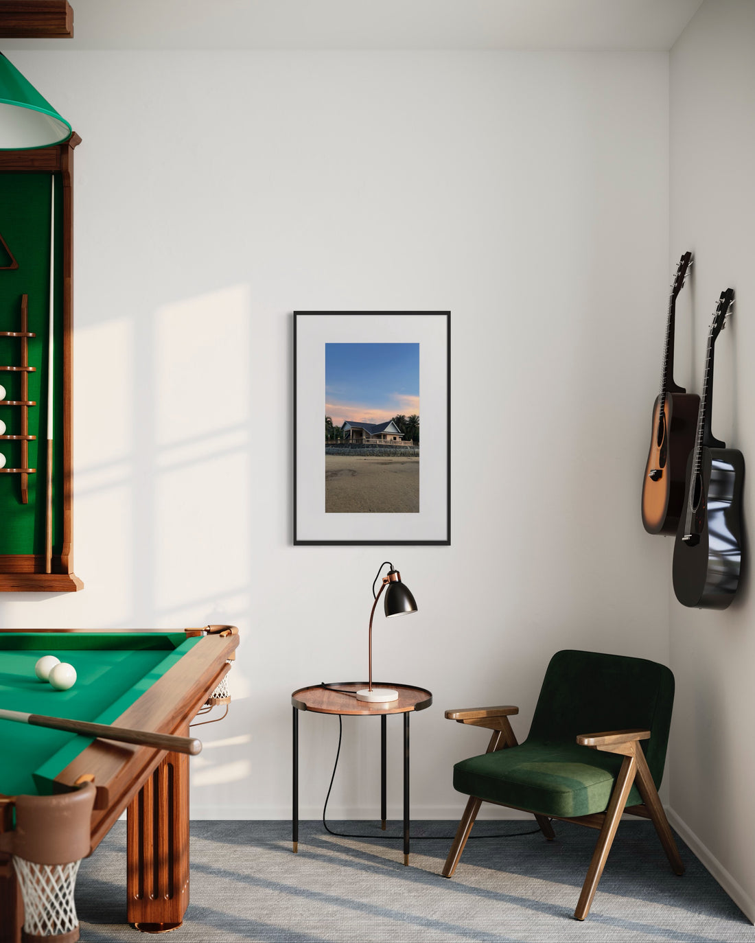 Stilvolles Wohnzimmer mit grünem Samtsessel, runder Holzbeistelltisch mit Lampe, Wand mit montierter Gitarre neben Billardtisch und Regal für Queue-Sticks, über dem ein gerahmtes Bild von einem Haus bei Sonnenuntergang hängt.