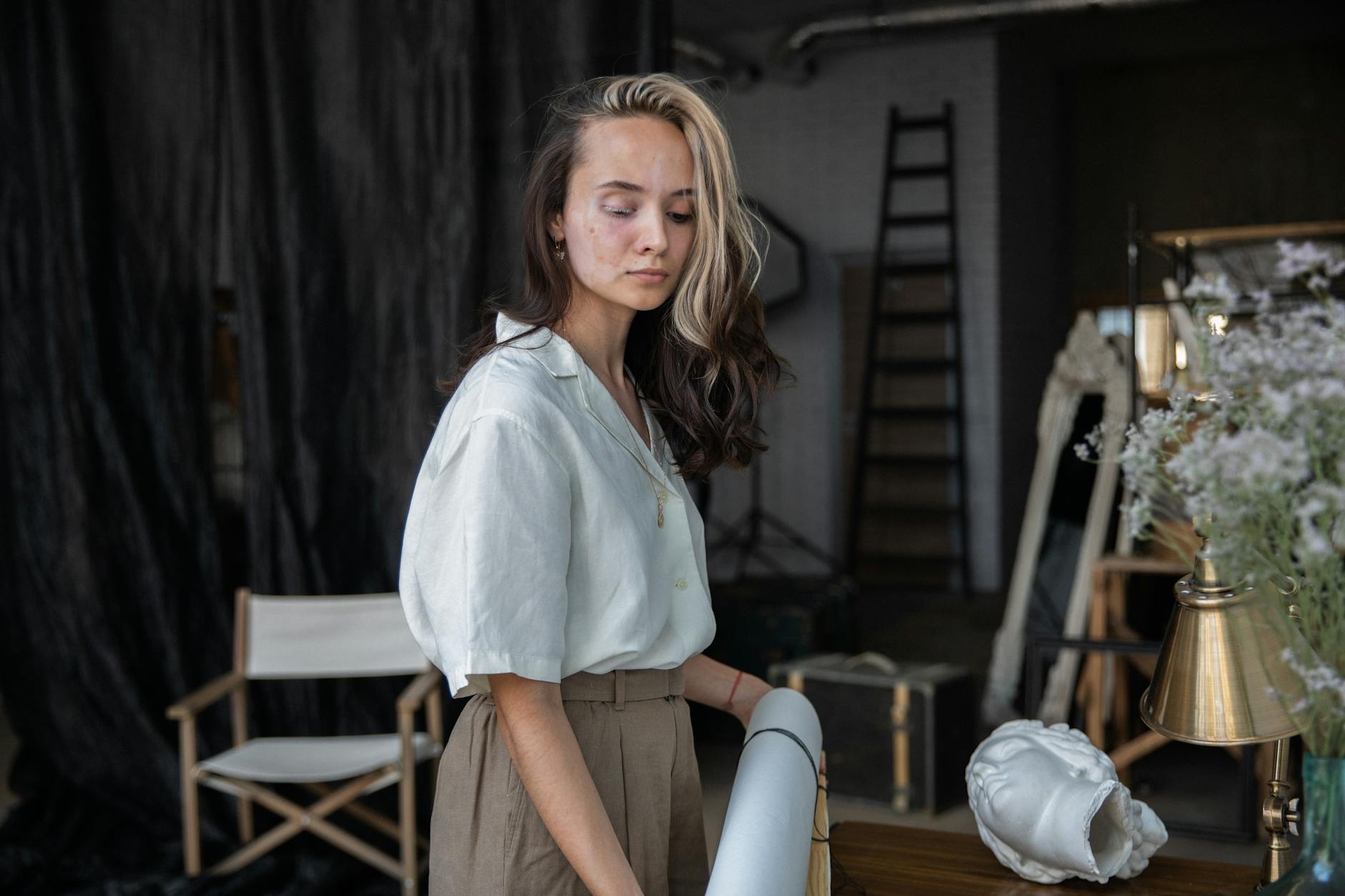 Female artist working in a modern studio surrounded by artworks